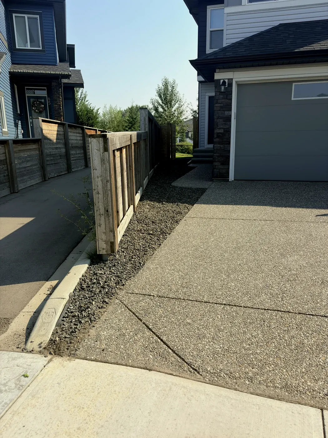 Rock strip along the fence weeded clean from curb to gate by Edge Property Services; Calgary
