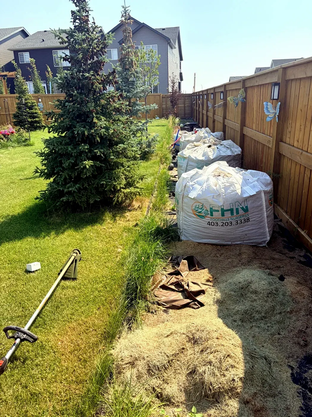 Fence line before new garden bed installation; Calgary