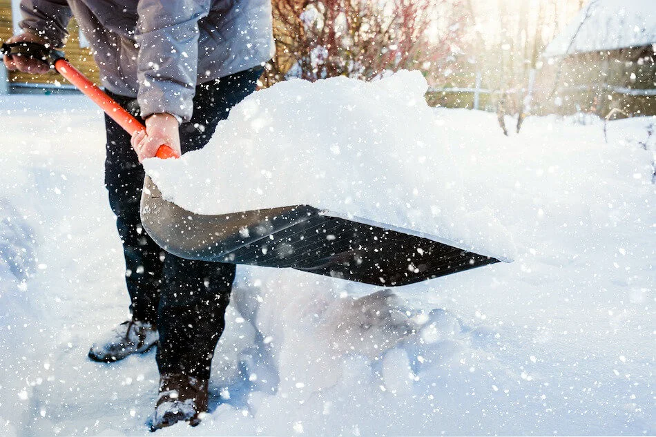 Shovelling snow in falling flakes during a winter storm